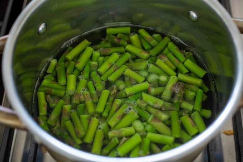 blanch the cut asparagus in a pot of water.