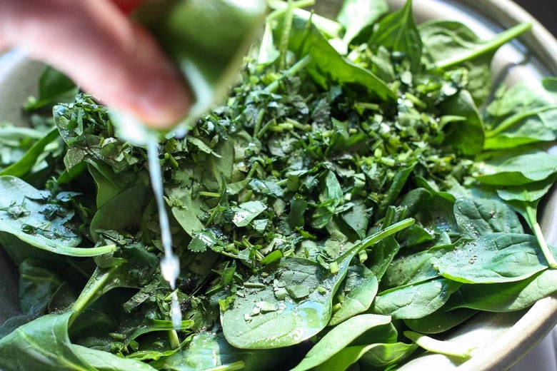 place spinach and cilantro in a bowl and squeeze with lime