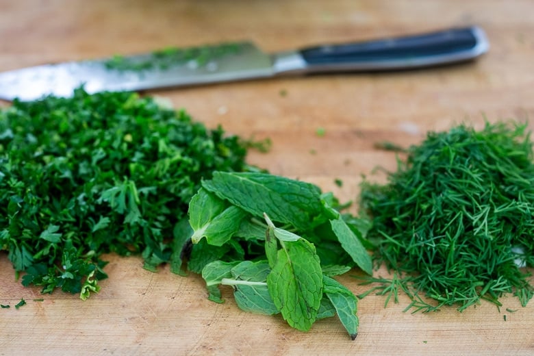 chopping mint, parsley and dill for the slaw
