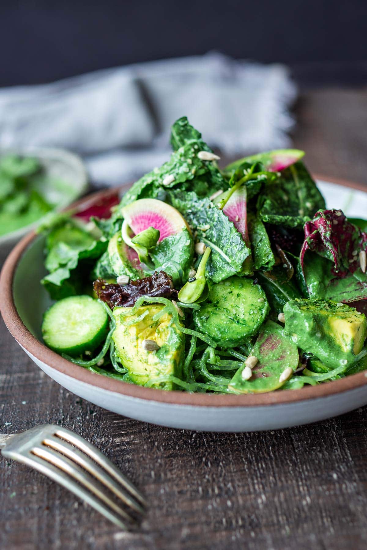 Seaweed salad tossed with greens in a bowl. 