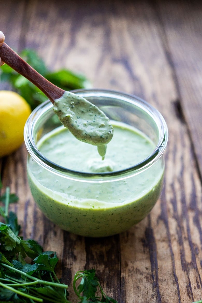 Flavorful Green Tahini Sauce made with tahini paste, fresh herbs, garlic, lemon and a few slices of green chilies. Perfect vegan condiment to serve with falafels, pita bread, shawarma, mezze platters! #tahinisauce #tahini #vegan