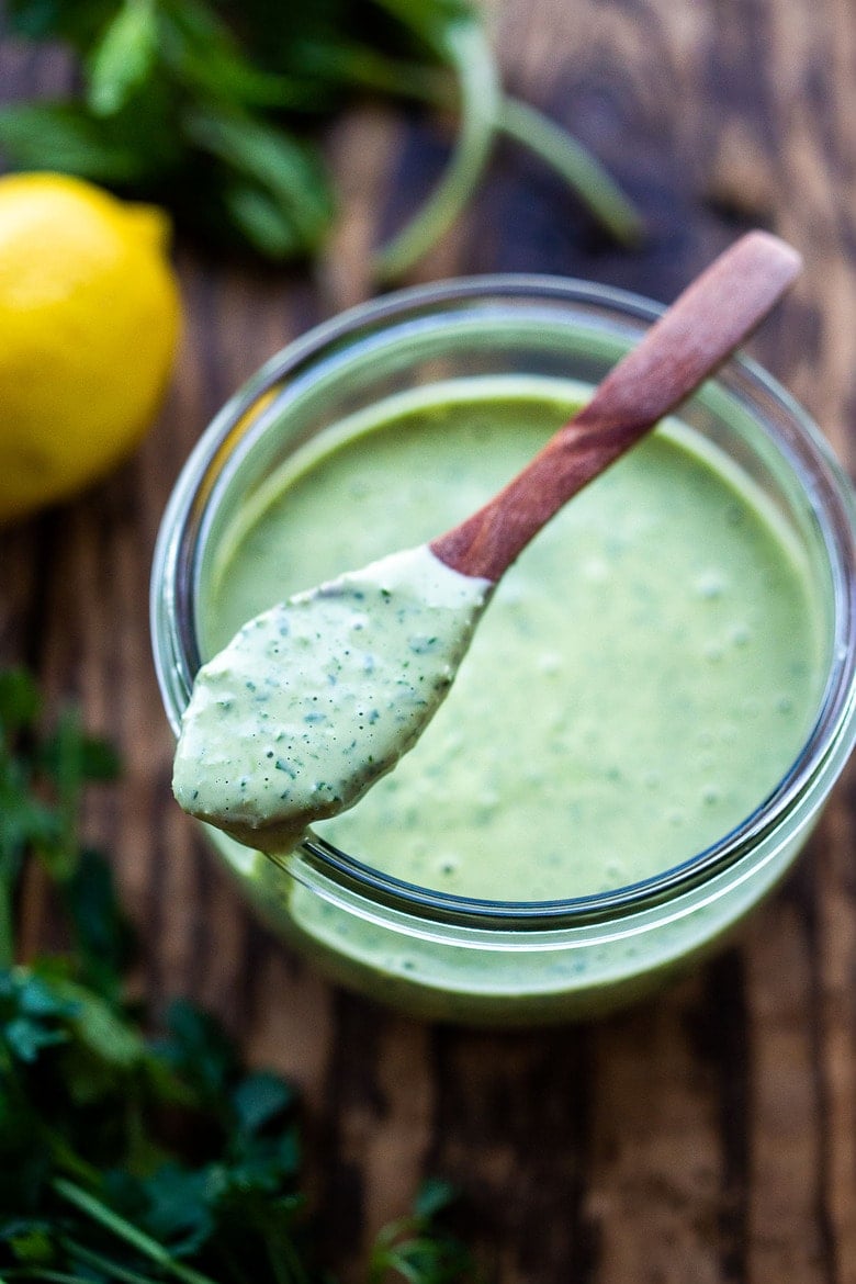 Flavorful Green Tahini Sauce made with tahini paste, fresh herbs, garlic, lemon and a few slices of green chilies. Perfect vegan condiment to serve with falafels, pita bread, shawarma, mezze platters! #tahinisauce #tahini #vegan