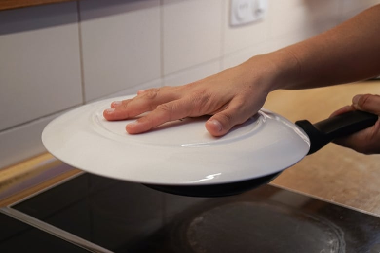 Flip the tortilla placing a plate over the skillet