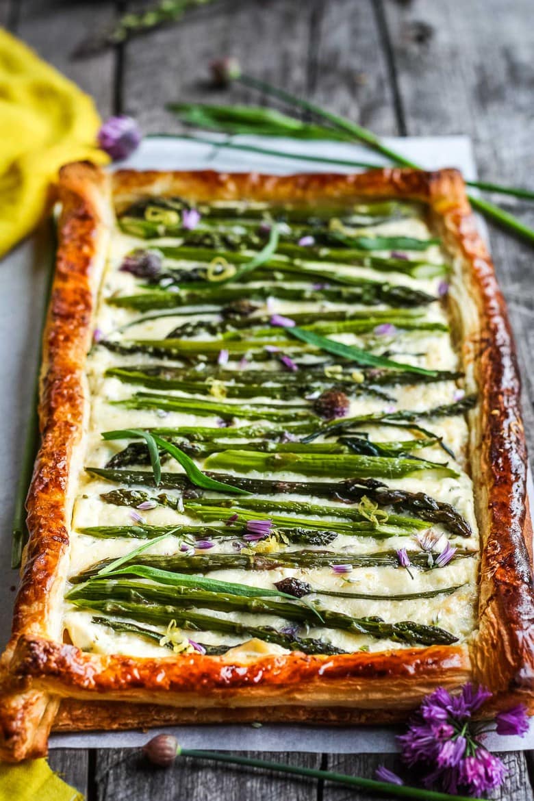 asparagus tart with golden puff pastry crust, cheesy filling, asparagus and chive blossoms.