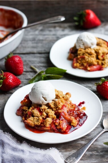 A scrumptious Strawberry Rhubarb Cobbler is infused with ginger and orange zest and topped with a golden corn flour crust. #strawberrycrumble #strawberrycobbler