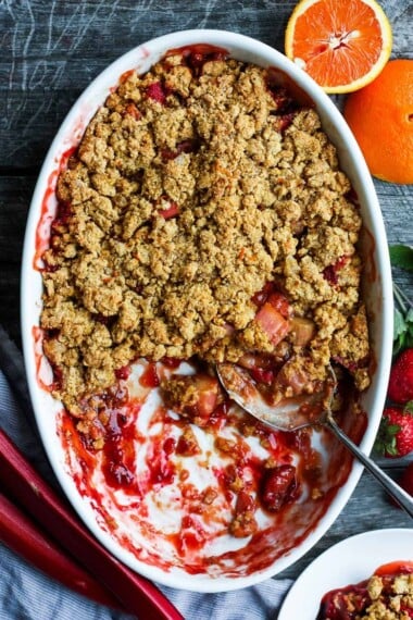 A scrumptious Strawberry Rhubarb Cobbler is infused with ginger and orange zest and topped with a golden corn flour crust. #strawberrycrumble #strawberrycobbler