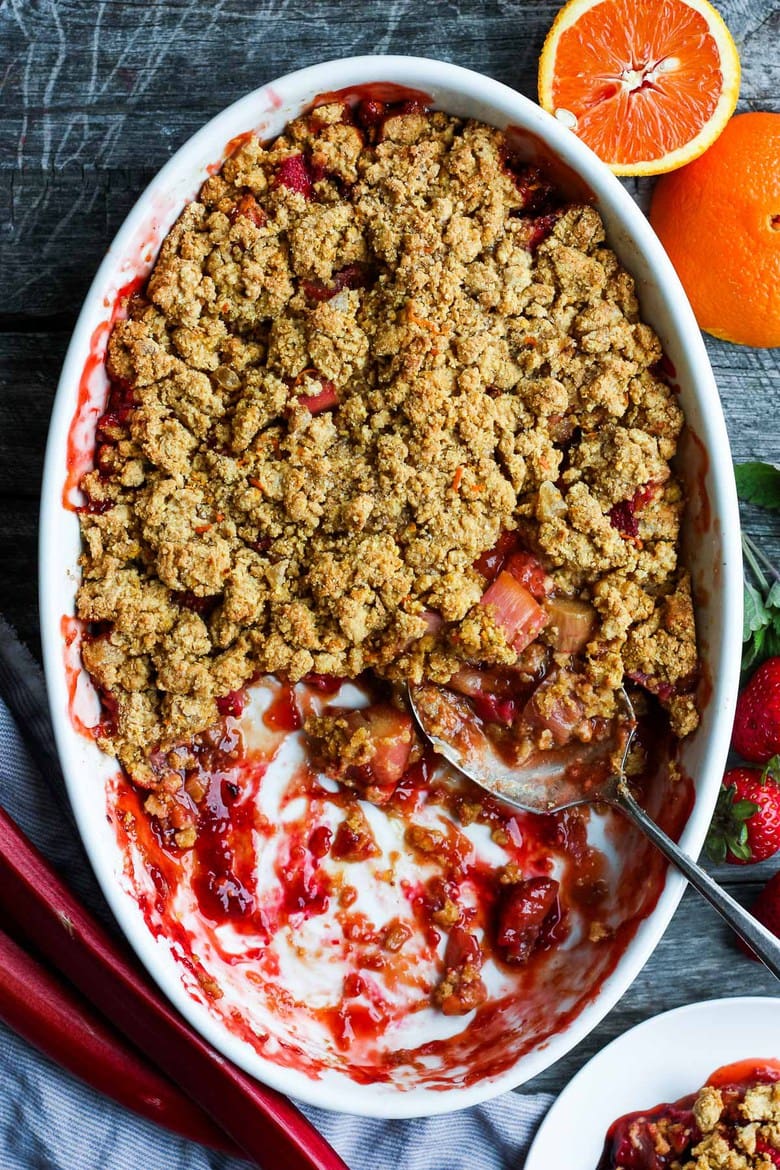 A scrumptious Strawberry Rhubarb Cobbler is infused with ginger and orange zest and topped with a golden corn flour crust. Definitely potluck worthy! #strawberrycrumble #strawberrycobbler