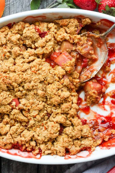 A scrumptious Strawberry Rhubarb Cobbler is infused with ginger and orange zest and topped with a golden corn flour crust. #strawberrycrumble #strawberrycobbler
