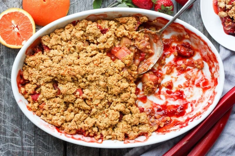 A scrumptious Strawberry Rhubarb Cobbler is infused with ginger and orange zest and topped with a golden corn flour crust. #strawberrycrumble #strawberrycobbler
