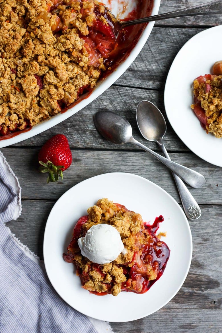 A scrumptious Strawberry Rhubarb Cobbler is infused with ginger and orange zest and topped with a golden corn flour crust. #strawberrycrumble #strawberrycobbler