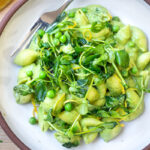This Creamy Vegan Pea Pasta is lathered up in the most delicious, luscious sauce made with fresh (or frozen) English peas and mint without a lick of dairy! Happy little shells cradle a vibrant, creamy green sauce made up of peas and mint. #vegan #peapasta #veganpasta