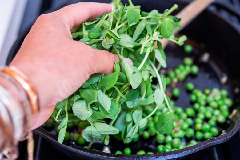 Add fresh pea shoots to the pan and wilt.