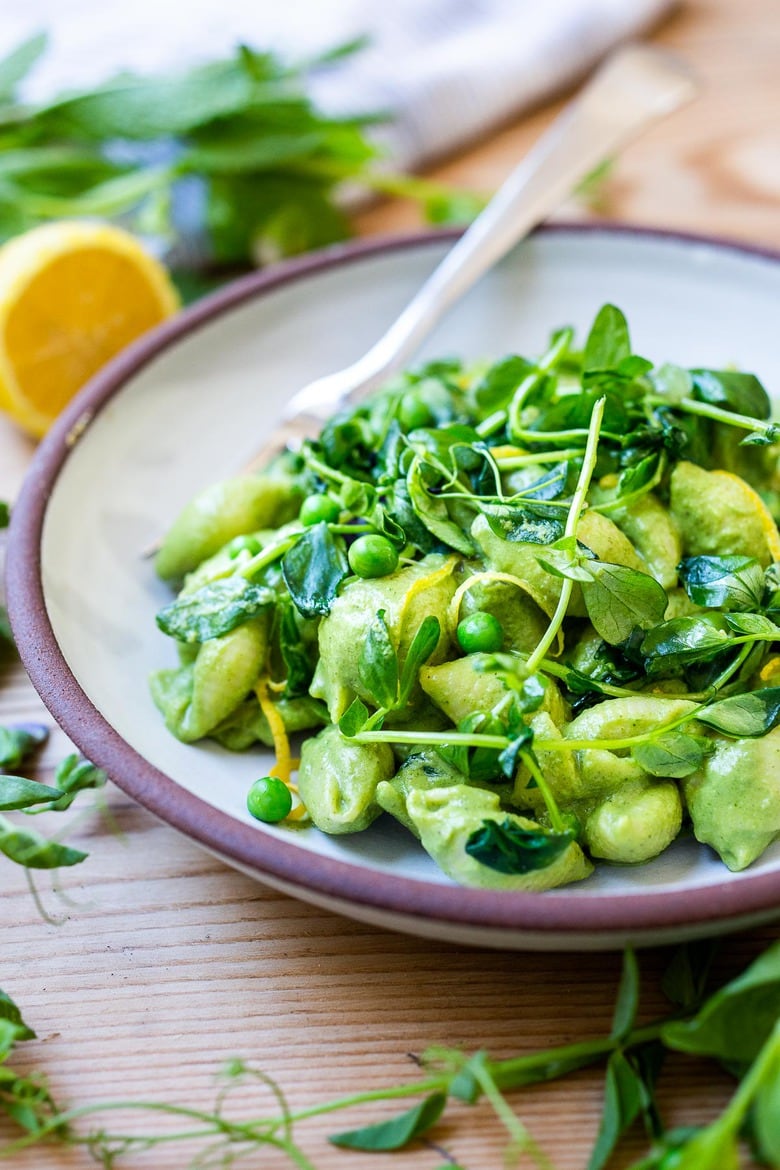 This Creamy Vegan Pea Pasta is lathered up in the most delicious, luscious sauce made with fresh (or frozen) English peas and mint without a lick of dairy! Happy little shells cradle a vibrant, creamy green sauce made up of peas and mint. #vegan #peapasta #veganpasta