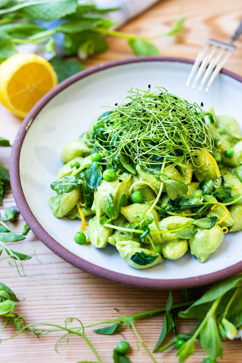 This Creamy Vegan Pea Pasta is lathered up in the most delicious, luscious sauce made with fresh (or frozen) English peas and mint without a lick of dairy! Happy little shells cradle a vibrant, creamy green sauce made up of peas and mint. #vegan #peapasta #veganpasta