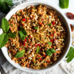 Moroccan Cauliflower "Couscous" made with riced cauliflower, dried apricots, toasted almonds and fragrant Moroccan spices, tossed with fresh parsley, mint and a lemon honey drizzle. Gluten-free, healthy and vibrantly flavorful! Vegan-adaptable. #cauliflower #cauliflowerrice #couscous