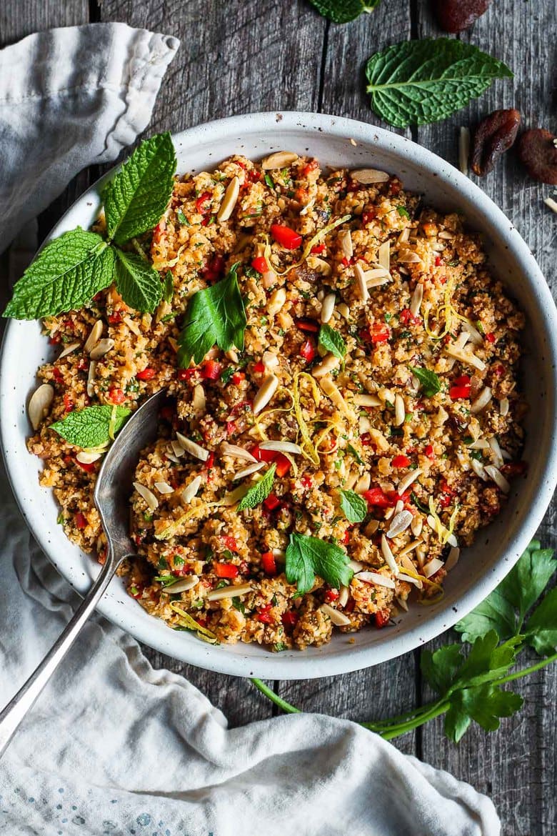 Moroccan Cauliflower "Couscous" made with riced cauliflower, dried apricots, toasted almonds and fragrant Moroccan spices, tossed with fresh parsley, mint and a lemon honey drizzle.   Gluten-free, healthy and vibrantly flavorful! Vegan-adaptable. #cauliflower #cauliflowerrice #couscous