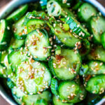 Asian Cucumber Salad made with rice vinegar, sesame, ginger, garlic and soy is cool and refreshing and pairs well with many things. It's vegan and gluten-free and is a nice addition to meals and bowls you are already making! #cucumbersalad