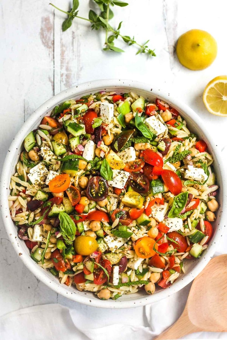 This healthy Greek Pasta Salad is the perfect make-ahead pasta salad for summertime picnics, bbqs, potlucks and easy dinners.  A hearty ratio of fresh veggies combined with tender orzo pasta, chickpeas tossed in the tastiest Greek salad dressing.#greekpastasalad