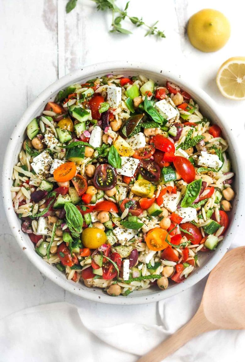 This healthy Greek Pasta Salad is the perfect make-ahead pasta salad for summertime picnics, bbqs, potlucks and easy dinners.  A hearty ratio of fresh veggies combined with tender orzo pasta, chickpeas tossed in the tastiest Greek salad dressing.#greekpastasalad