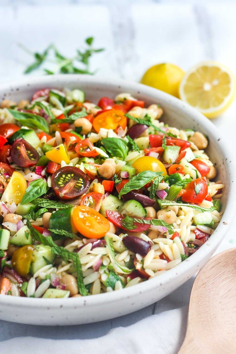 This healthy Greek Pasta Salad is the perfect make-ahead pasta salad for summertime picnics, bbqs, potlucks and easy dinners.  A hearty ratio of fresh veggies combined with tender orzo pasta, chickpeas tossed in the tastiest Greek salad dressing.#greekpastasalad