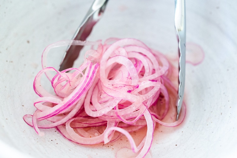 toss the onions with the vinegar and salt to remove bitterness