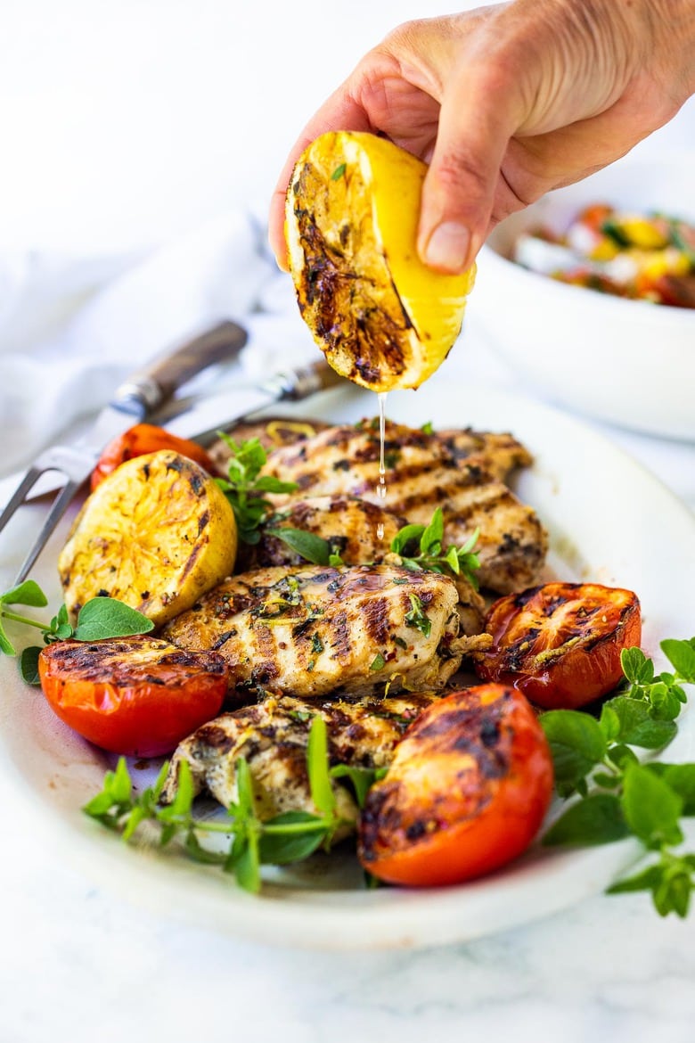 A simple, easy recipe for the juiciest, most flavorful Grilled Lemon Herb Chicken with grilled lemons, that turns out perfect every time.  Make this with skinless chicken breast or chicken thighs to pair with salads or veggies. #grilledchickenbreast #grilledchicken