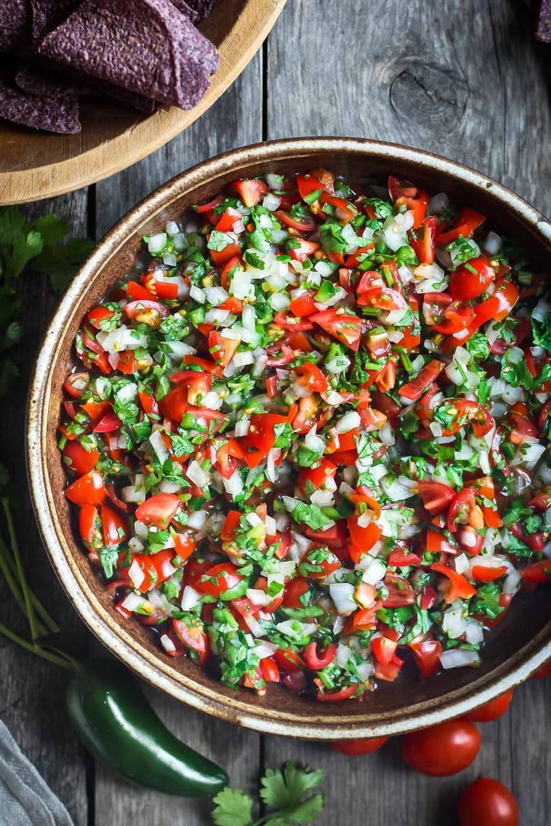 Fresh and simple Pico De Gallo is the perfect condiment for hot summer days. Easy to make with just a few ingredients- this fresh Mexican salsa will enliven all your Mexican favorites - delicious on tacos, burritos, enchiladas and eggs, or a simple tasty appetizer served with tortilla chips! #picodegallo