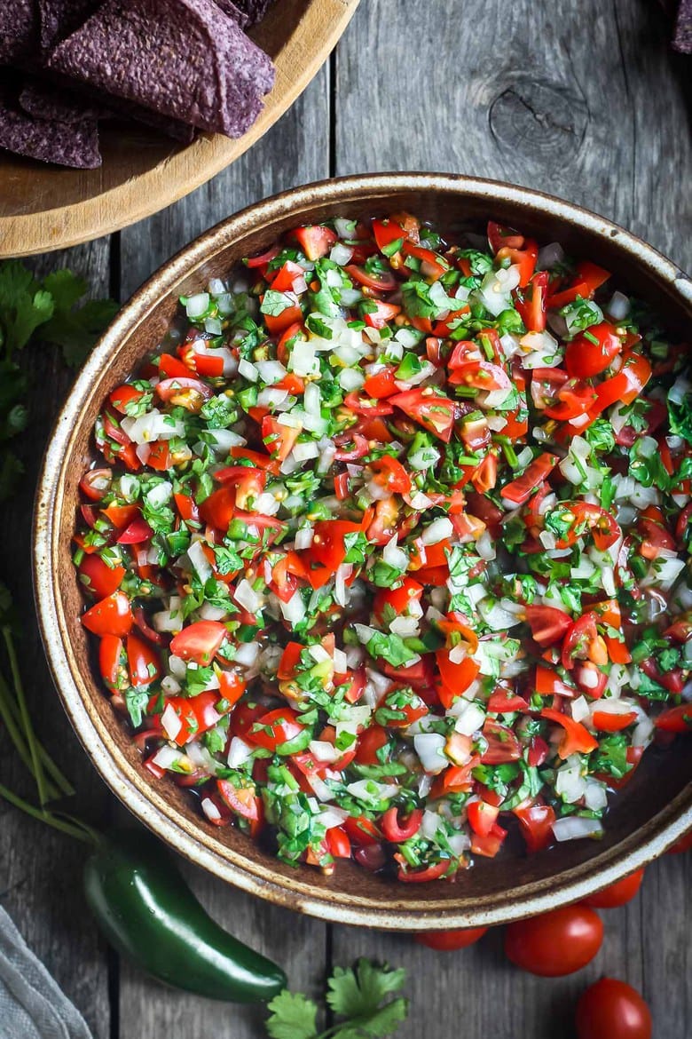 Fresh and simple Pico De Gallo is the perfect condiment for hot summer days.  Easy to make with just a few ingredients- this fresh Mexican salsa will enliven all your Mexican favorites - delicious on tacos, burritos, enchiladas and eggs, or a simple tasty appetizer served with tortilla chips! #picodegallo