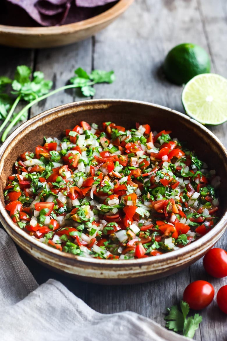 Fresh and simple Pico De Gallo is the perfect condiment for hot summer days.  Easy to make with just a few ingredients- this fresh Mexican salsa will enliven all your Mexican favorites - delicious on tacos, burritos, enchiladas and eggs, or a simple tasty appetizer served with tortilla chips! #picodegallo