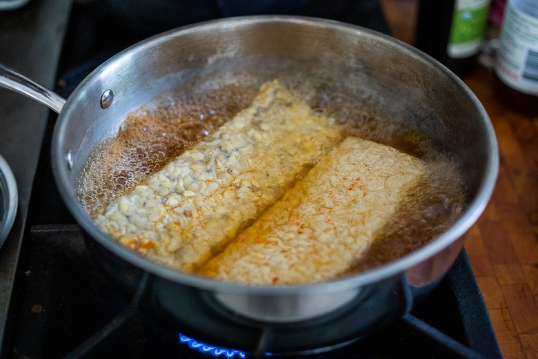 tempeh simmering in a pan.