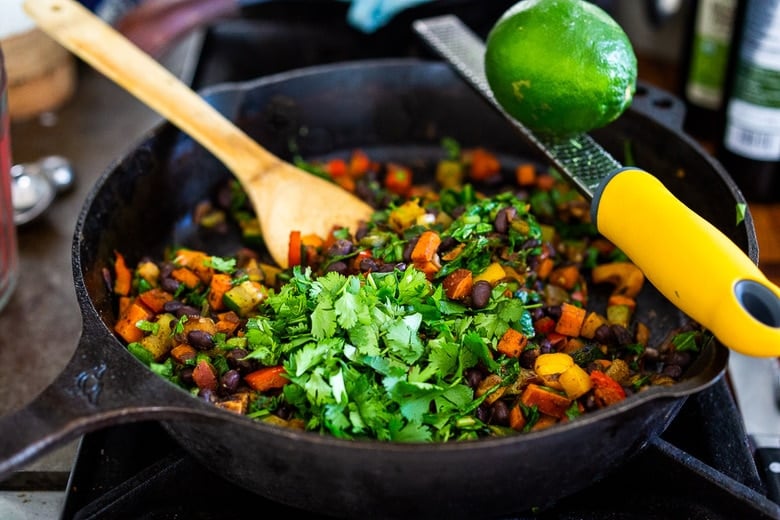 cilantro and lime zest being added to the pan