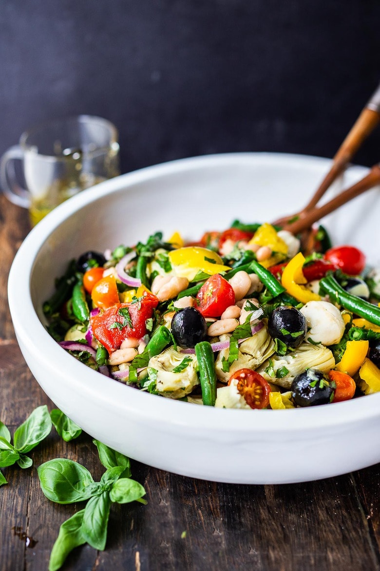 Veggie-loaded Antipasta Salad with white beans (or Tuna), artichoke hearts, olives, capers, fresh veggies, red onion, lots of herbs, tossed in a simple Italian dressing. Vegan and Low Carb adaptable!