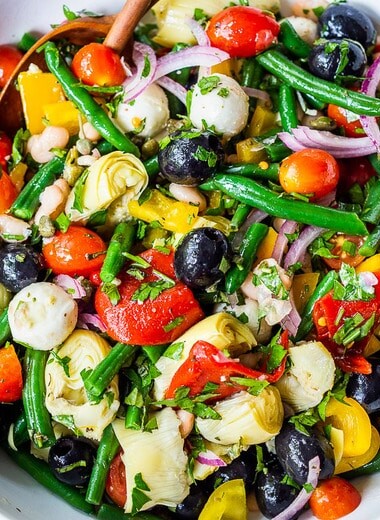 Antipasto Salad with white beans, aritchoke hearts, olives, fresh veggies, and lots of herbs, tossed in a simple Italian dressing. Vegan and Low Carb adaptable!