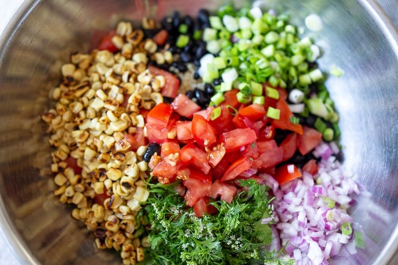 place black bean quinoa salad ingredients in a bowl and toss