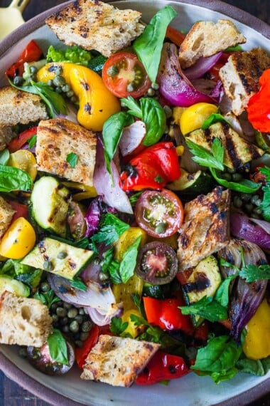 Delicious Grilled Panzanella Salad with colorful sweet bell peppers, artichoke hearts, and white beans tossed in a flavorful white balsamic dressing.  Make it on the barbecue for an easy outdoor summer meal with your favorite grilled protein!  Vegan!