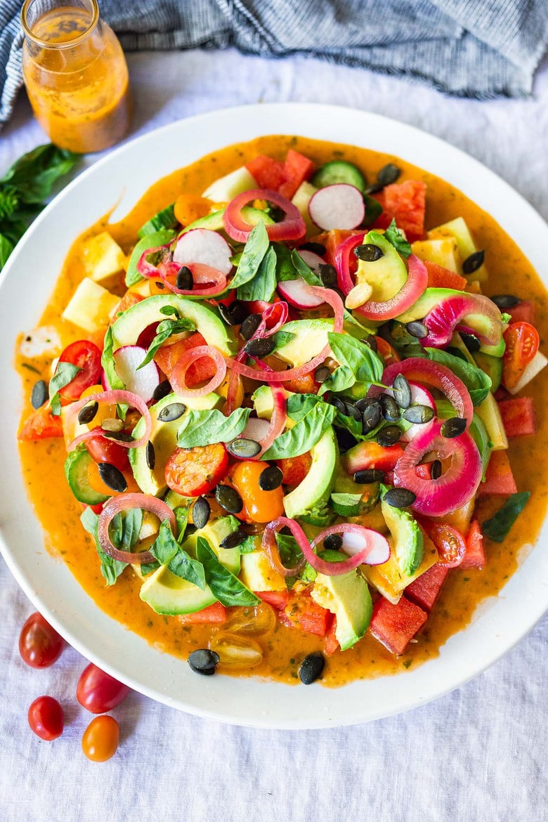 Cooling, refreshing Watermelon Salad with tomatoes, avocado,  pickled shallots, radishes, pumpkin seeds, and basil,  tossed in a flavorful Tomato Vinaigrette. Vegan and Gluten-free.