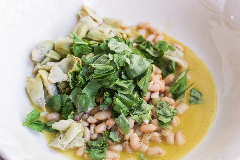 beans and artichokes in bowl with vinaigrette