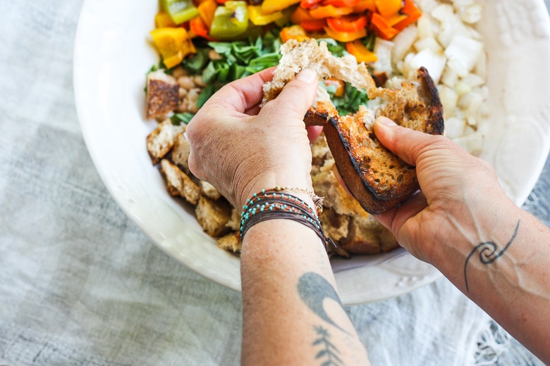 tearing bread into the salad