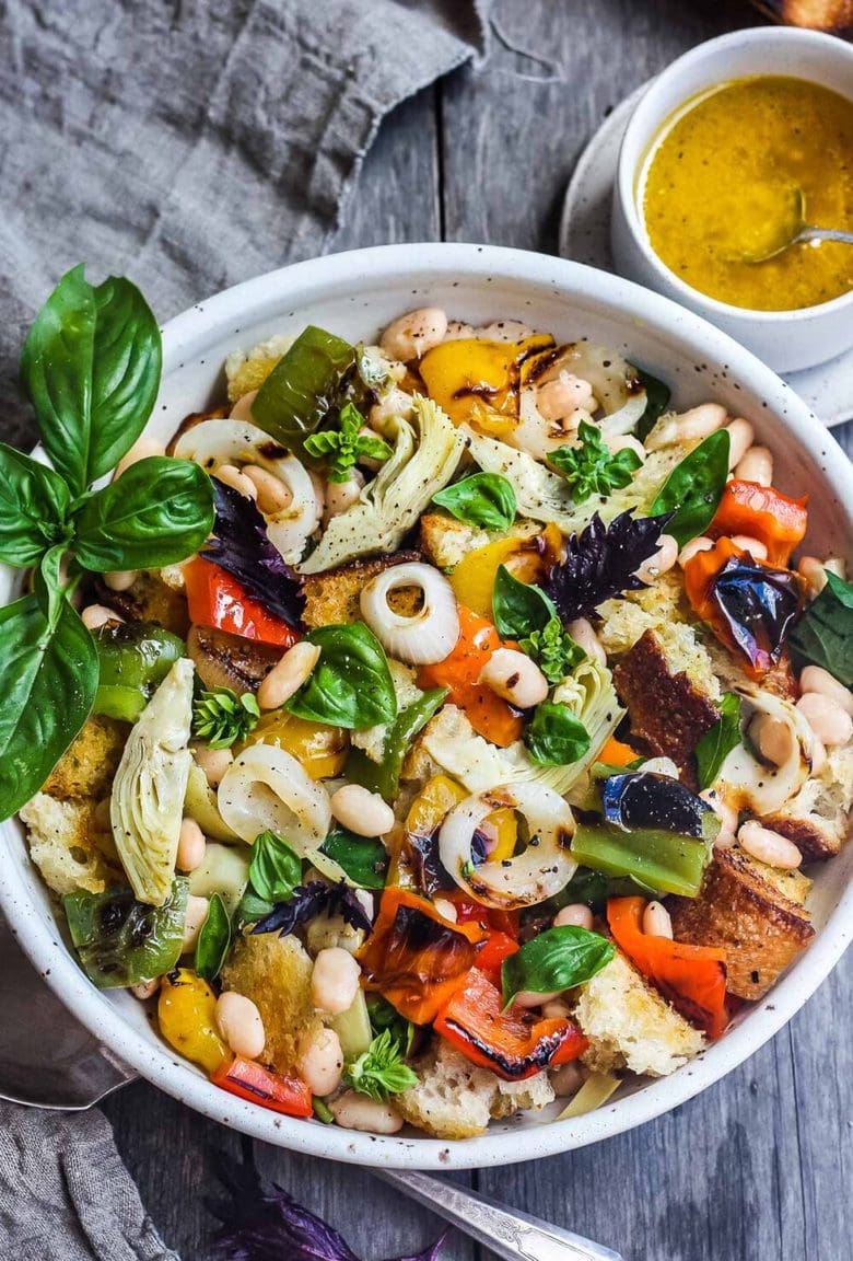 Delicious Grilled Tuscan Bread Salad with colorful sweet bell peppers, artichoke hearts and white beans tossed in a flavorful white balsamic dressing. Make it on the barbecue for an easy outdoor summer meal with your favorite grilled protein! Vegan!