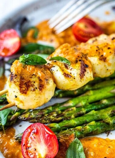 Grilled Scallops, marinated with olive oil, orange zest, coriander, salt and pepper, topped with Charred Tomato Vinaigrette. A delicious summer dinner that is fast, easy, light, refreshing and elegant! #grilledscallops