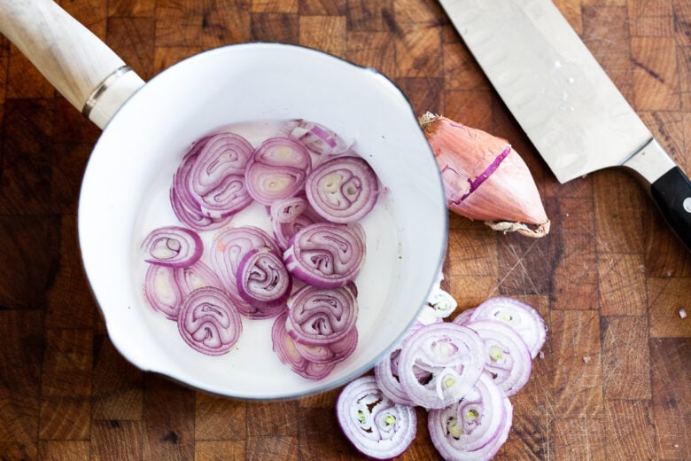 Sliced shallots in a pan.