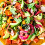 Cooling, refreshing Tomato Melon Salad with cucumber, radishes, avocado, basil, pumpkin seeds and pickled shallots tossed in the most flavorful Tomato Vinaigrette. #tomatosalad #melonsalad