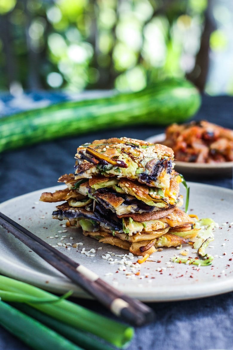 These Korean-inspired Zucchini Scallion Pancakes are a simple tasty treat!  No-fuss preparation and ready to serve in minutes.  Packed with zucchini and scallions, held together with rice flour and eggs, heavy on the veggies.  Seasoned with gochujang pepper chili paste and a touch of rice wine, they are filled with savory flavor.