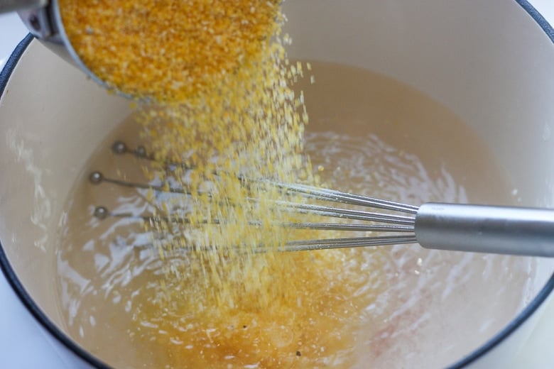 whisking polenta into boiling water