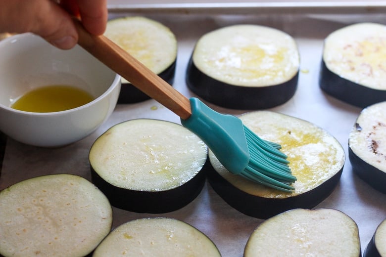 brushing olive oil on eggplant slices