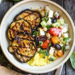 Perfectly tender smoky Grilled Eggplant with fresh Greek relish and creamy polenta. An easy and healthy meatless dinner. Vegan adaptable and gluten-free.