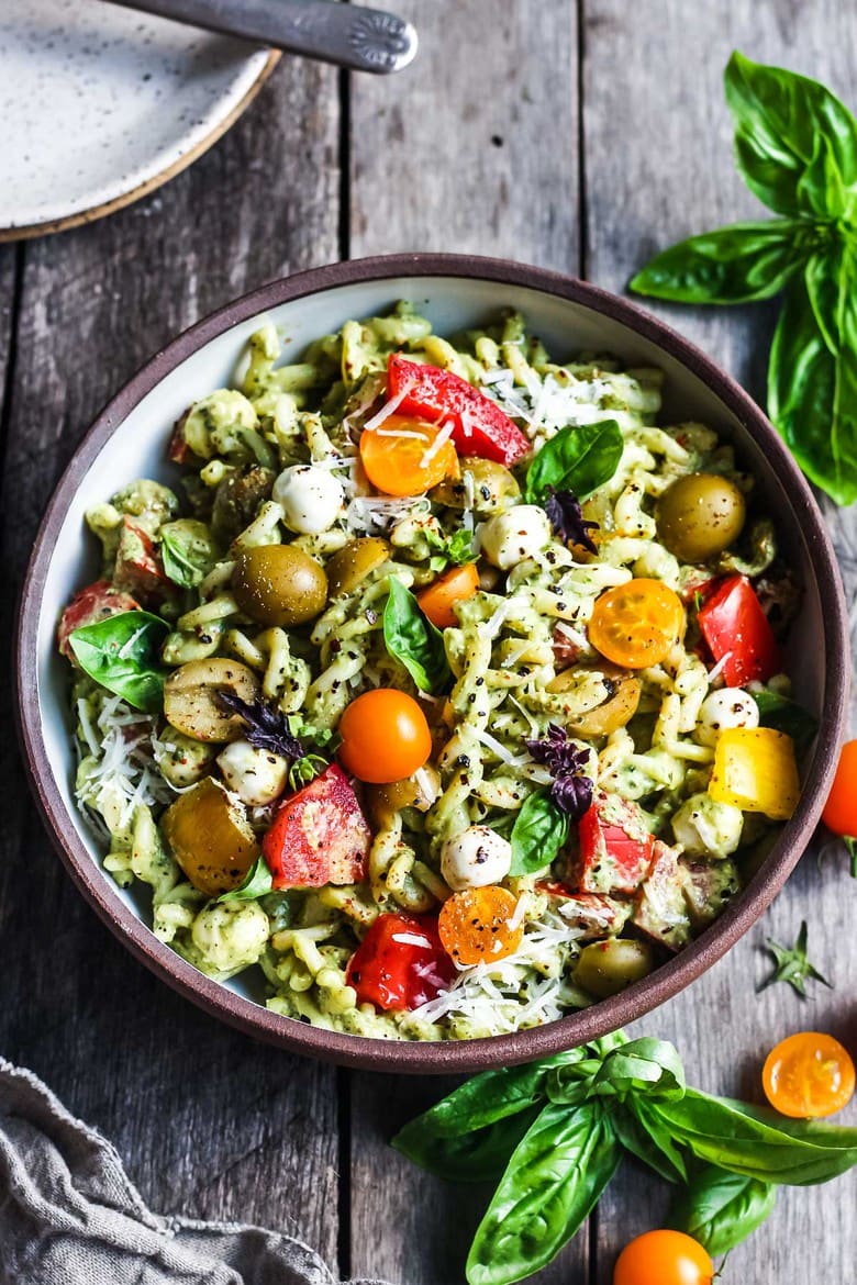 Pesto Pasta Salad w/ cherry tomatoes, baby mozzarella, olives & fresh basil tossed in a Creamy Pesto Dressing. A classic potluck favorite! Vegan, gluten-free adaptable.