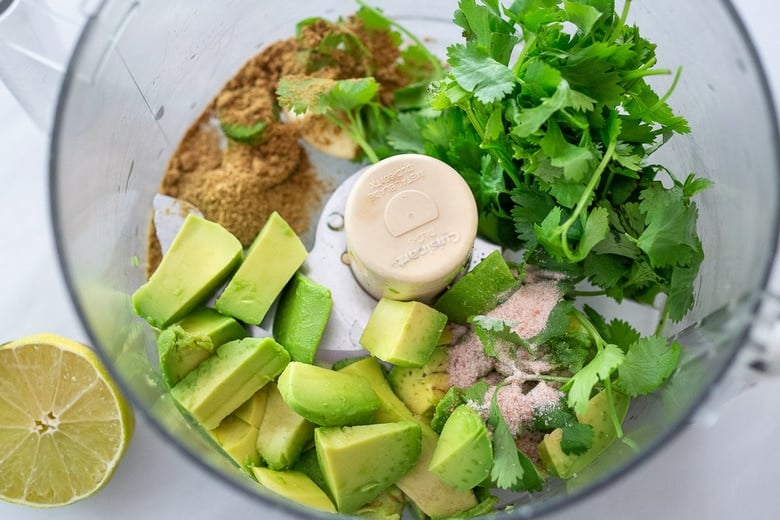  avocado sauce ingredients in a food processor. 