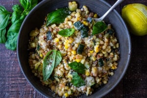 Fregola with Corn, Zucchini and Basil, sprinkled with pecorino. A fast and easy Italian-inspired meal that comes together in 30 minutes.