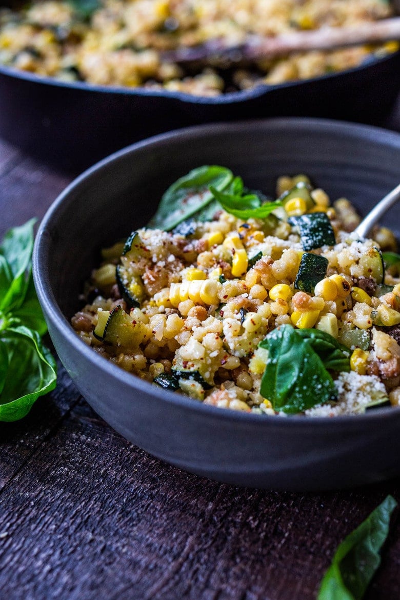 Fregola with Corn, Zucchini and Basil, sprinkled with pecorino. A fast and easy Italian-inspired meal that comes together in 30 minutes.